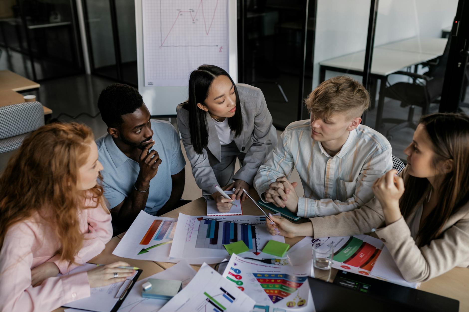 Zespół pracowników omawia strategię sieci biurowej przy stole