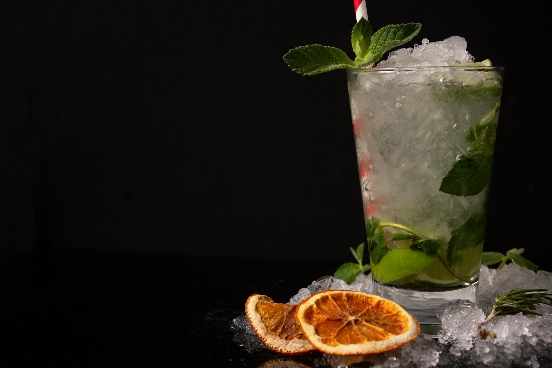 Koktajl mojito z miętą i plasterkiem suszonej pomarańczy na lodzie