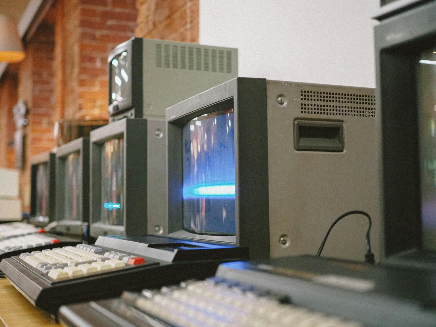 Rząd starych monitorów CRT w pomieszczeniu, klasyczna technologia komputerowa