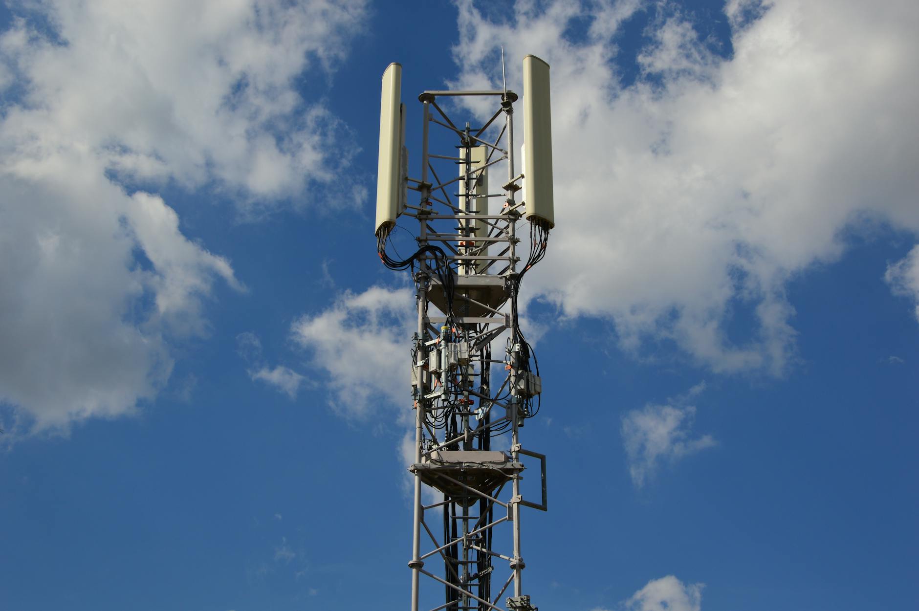 Maszt sieci komórkowej 5G na tle intensywnie błękitnego nieba