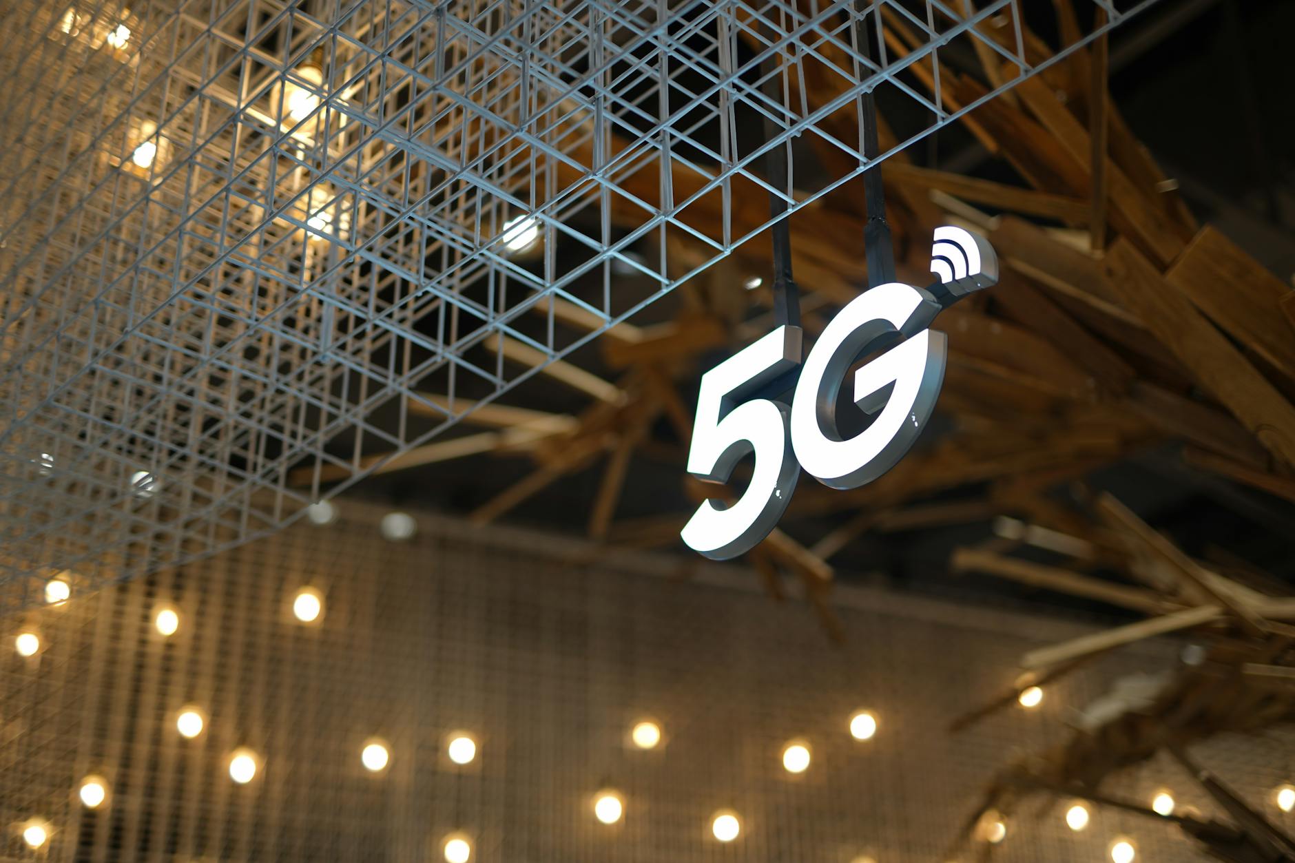 Architektura sieci 5G dla geeków: RAN, core, virtualizacja funkcji i orkiestracja NFV Podświetlony napis 5G na tle nowoczesnego sufitu z ciepłym oświetleniem