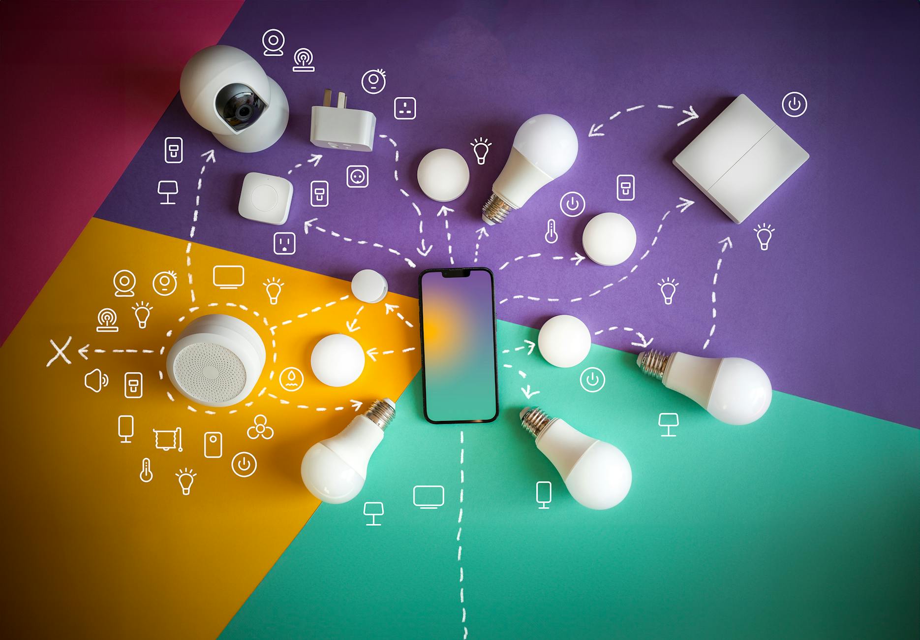 IoT w firmie: jak segmentować sieć, by urządzenia nie widziały reszty infrastruktury Smartfon i urządzenia smart home ułożone na biurku, symbol IoT w firmie