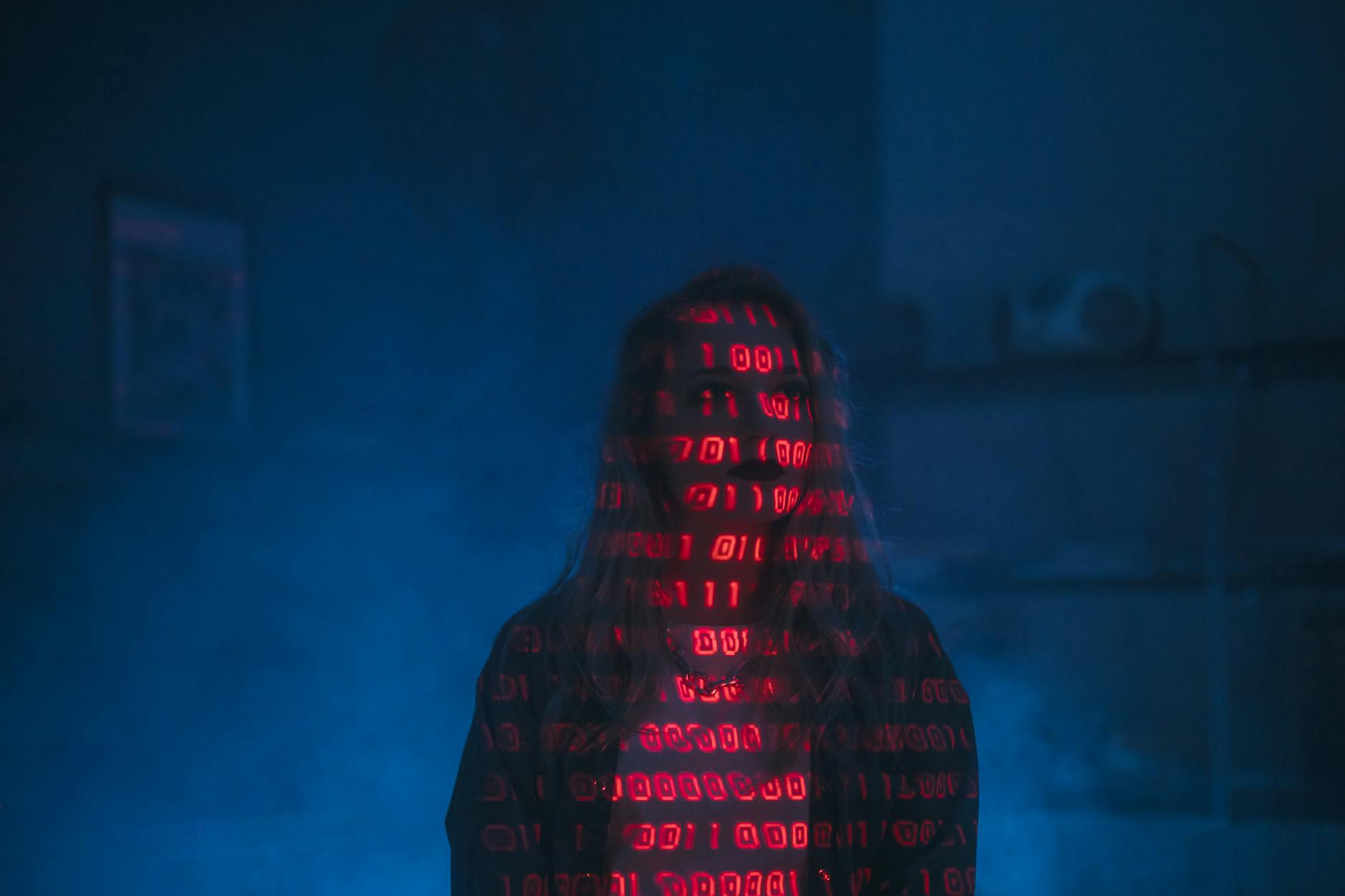 Zero Trust i szyfrowanie: jak nowy model bezpieczeństwa zmienia podejście do VPN Sylwetka w cieniu z czerwonym kodem binarnym na twarzy