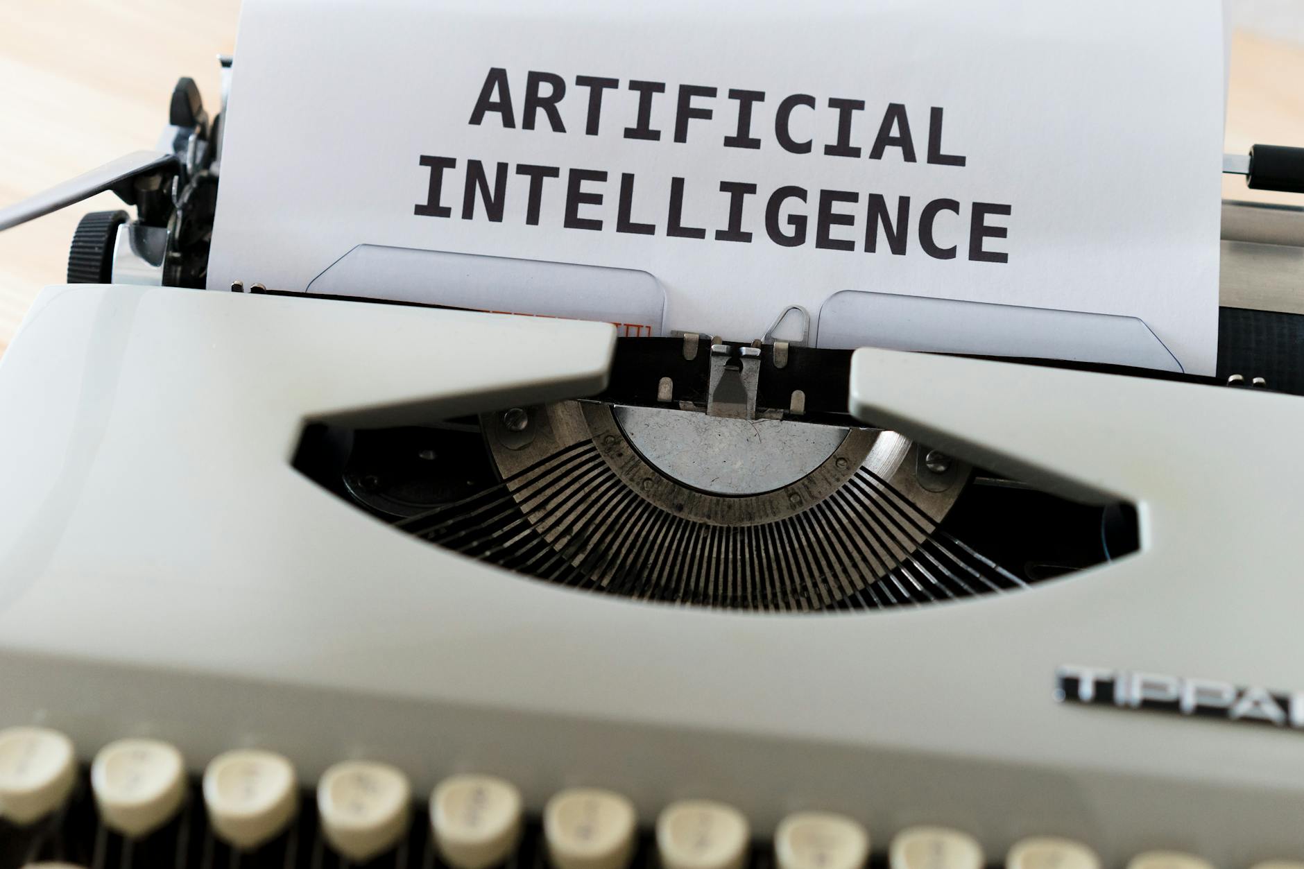 Zbliżenie na maszynę do pisania z tekstem artificial intelligence