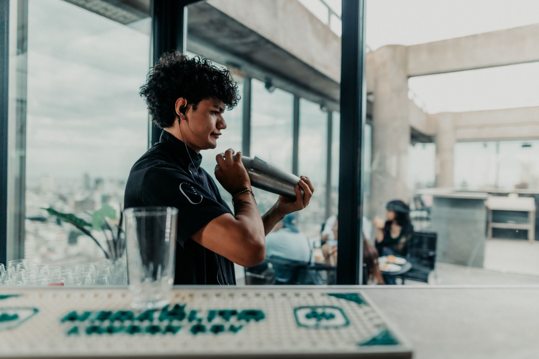 Barman miesza drinka na dachu baru w Buenos Aires z panoramą miasta