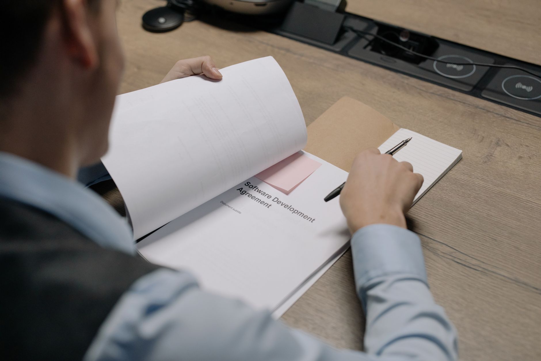 Licencjonowanie Microsoft 365 i Office 2021: praktyczne scenariusze dla firm i szkół Specjalista przy biurku analizuje umowę licencyjną oprogramowania