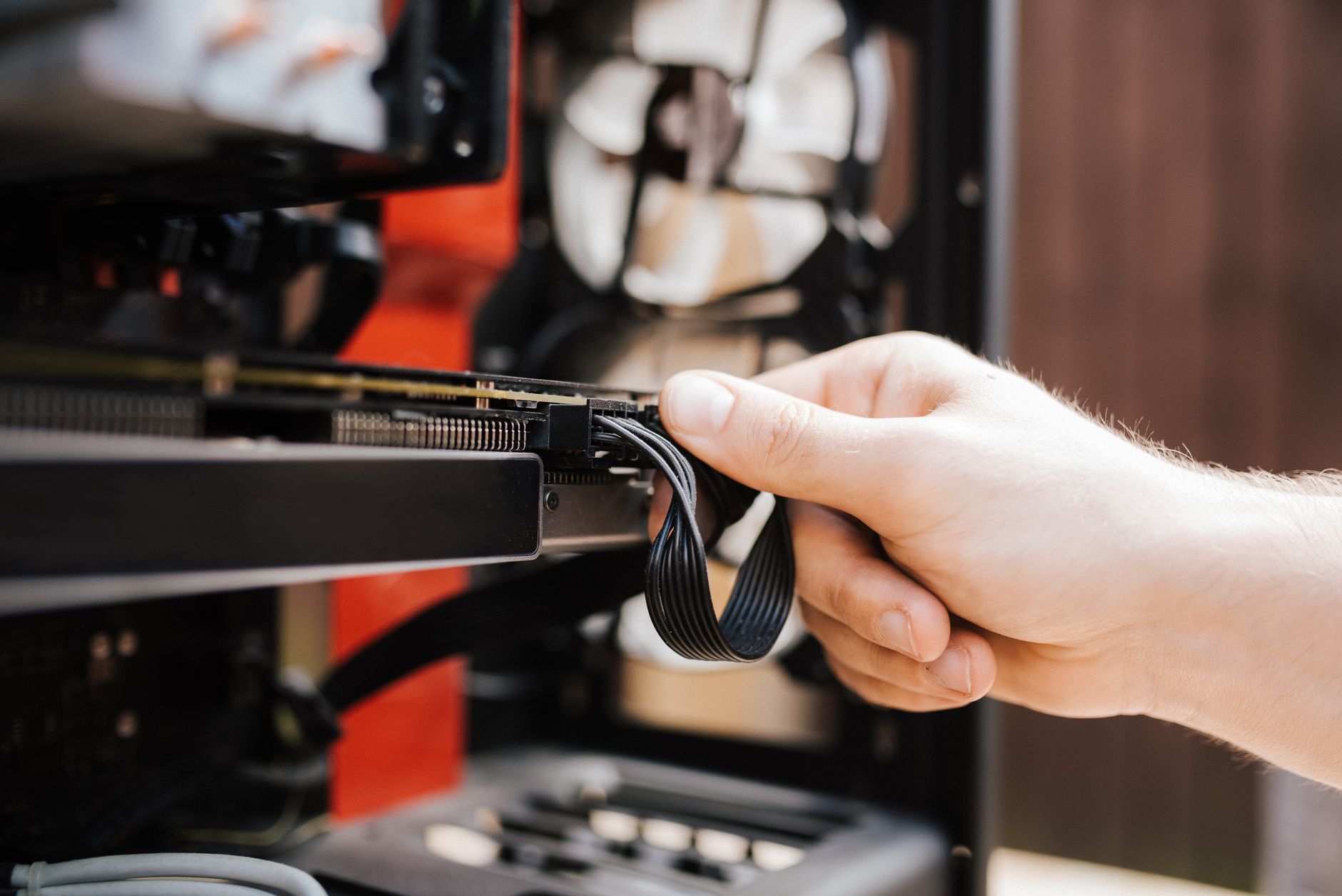 Modernizacja starego PC: które części warto wymienić, a co lepiej zostawić w spokoju Technik podłącza kable w nowoczesnej obudowie komputera PC